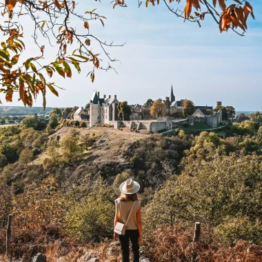 Point de vue du nommé Tertre Ganne en automne - Jeune femme qui regarde au loin vers la cité médiévale de Sainte-Suzanne en Mayenne.