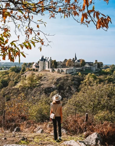 Point de vue du nommé Tertre Ganne en automne - Jeune femme qui regarde au loin vers la cité médiévale de Sainte-Suzanne en Mayenne.