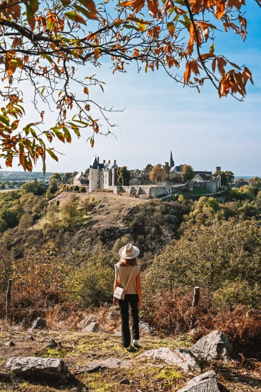 Point de vue du nommé Tertre Ganne en automne - Jeune femme qui regarde au loin vers la cité médiévale de Sainte-Suzanne en Mayenne.