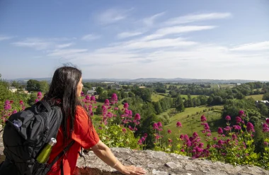 Une randonneuse regarde la vue sur les collines des Coëvrons