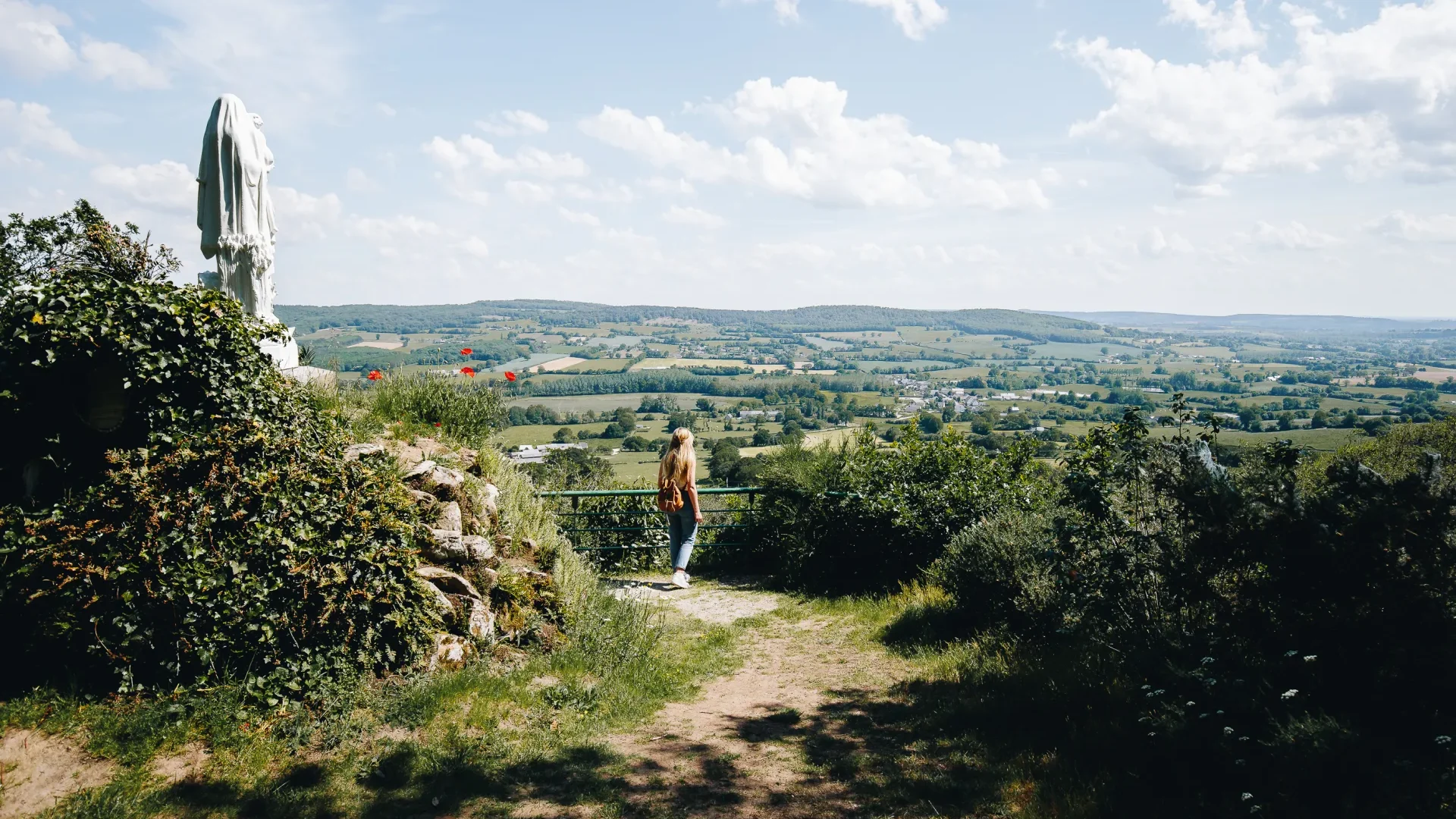 Une femme observant le paysage bocager de la Mayenne depuis de point de vue de Notre Dame des Champs en Mayenne dans les Coëvrons à Saint-Georges-sur-Erve