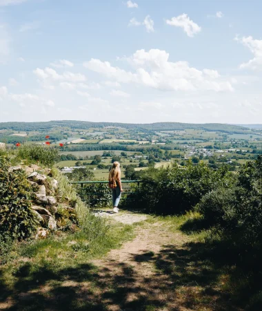 Une femme observant le paysage bocager de la Mayenne depuis de point de vue de Notre Dame des Champs en Mayenne dans les Coëvrons à Saint-Georges-sur-Erve