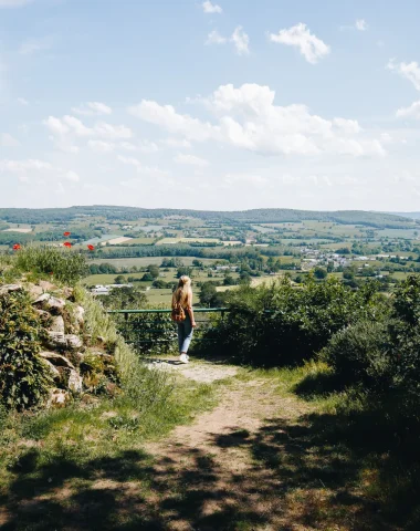 Une femme observant le paysage bocager de la Mayenne depuis de point de vue de Notre Dame des Champs en Mayenne dans les Coëvrons à Saint-Georges-sur-Erve