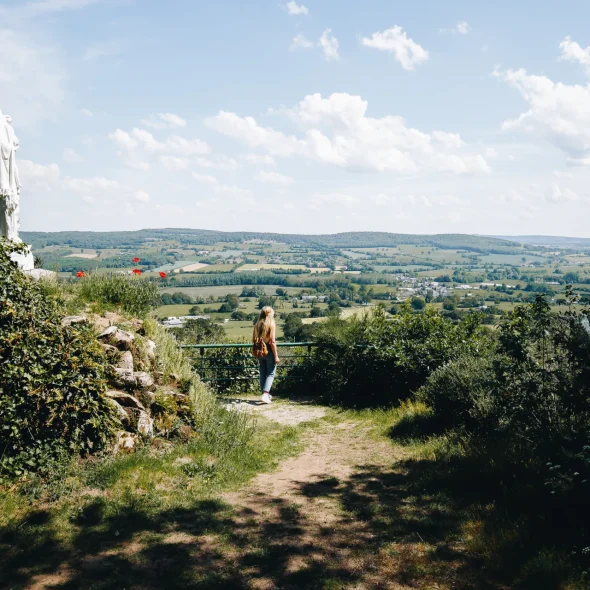 Une femme observant le paysage bocager de la Mayenne depuis de point de vue de Notre Dame des Champs en Mayenne dans les Coëvrons à Saint-Georges-sur-Erve